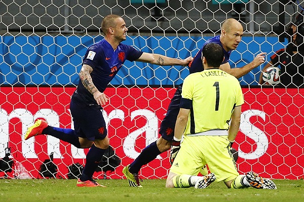 Футболисты сборной Голландии Уэсли Снейдер (слева) и Арьен Роббен (справа на втором плане) празднуют гол в ворота капитана сборной Испании Икера Касильяса (на первом плане).