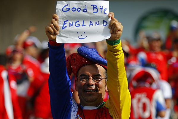 Болельщик Коста-Рики держит самодельный плакат с надписью "До свидания, Англия". После победы костариканцев над итальянскими футболистами сборная Англии потеряла все шансы на выход в плей-офф чемпионата мира.