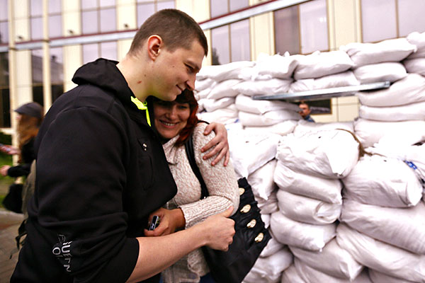 Солдат батальона воинской части Национальной гвардии Украины обнимает родственницу.