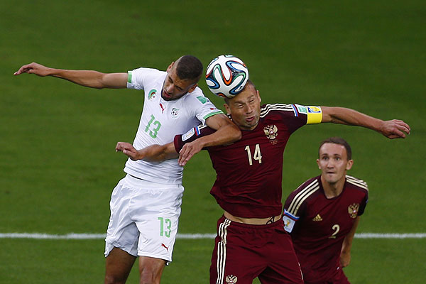 Капитан сборной России Василий Березуцкий борется за верховой мяч с алжирским нападающим Исламом Слимани. Россияне сыграли вничью с Алжиром и не вышли в плей-офф чемпионата мира.