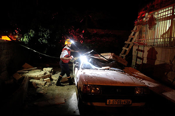 Работа пожарного на территории одного из домов предполагаемых похитителей израильских детей.