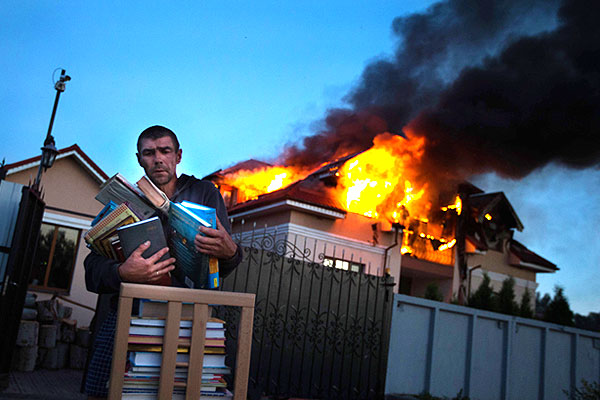 Житель села Николаевка спасает книги из горящего дома.
