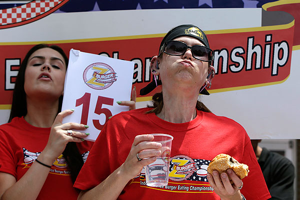 Молли Шулер, участница соревнований из Небраски, начинает жевать свой 16-й гамбургер.