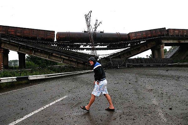 Местный житель обходит поврежденный мост.
