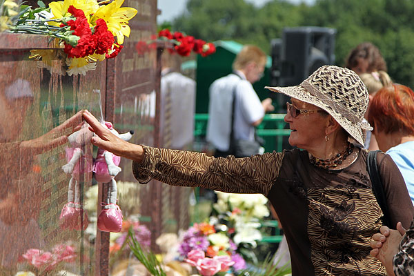 Женщина около мемориала в память о трагических событиях 10 июля 2011 года.