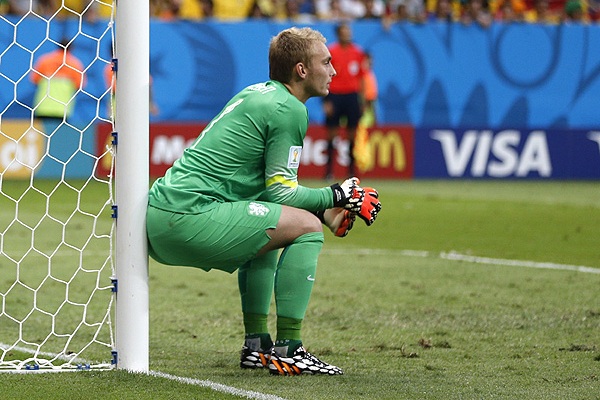 Голкипер сборной Голландии Яспер Силлессен наблюдает за тем, как его партнеры забивают три безответных мяча в ворота команды Бразилии.