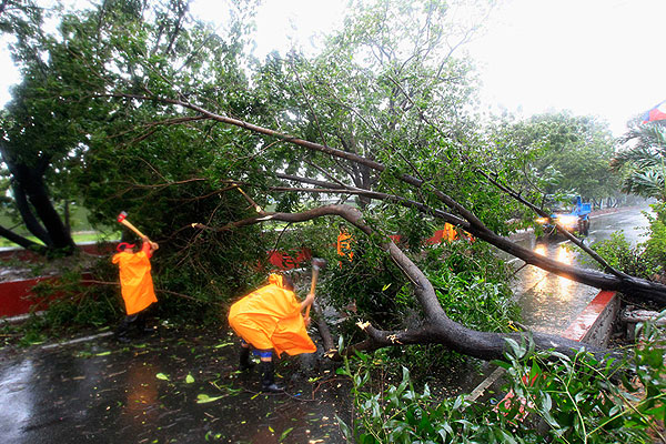 Муниципальные рабочие освобождают дорогу в Маниле.