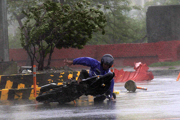 Мотоциклист, упавший на мокрой трассе.