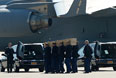 Перенос тел погибших из самолета в катафалки для транспортировки на военную базу в городе Хилверсум на севере Нидерландов.