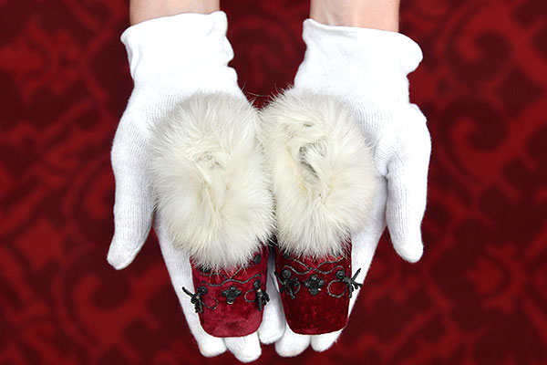 Экспонат британской выставки "Королевское детство" - бархатные пинетки, отороченные мехом, принадлежавшие в свое время маленькому Эдуарду VII.