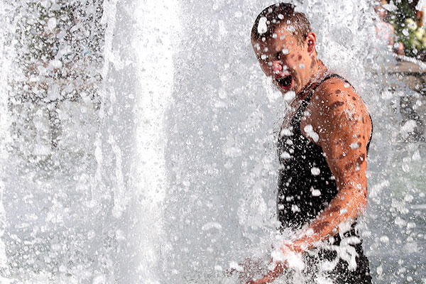 Молодой человек купается в фонтане на Манежной площади.