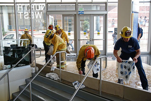 Пожарные сооружают плотину чтобы перегородить путь воде на нижние этажи.