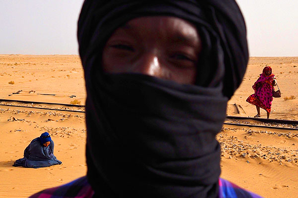 Молитва в дороге на Нуадибу. Мавританская железная дорога состоит из одной железнодорожной линии длиной в 704 км. Она соединяет центр рудодобывающих шахт Мавритании, город Зуэрат с портовым городом Нуадибу. Государственная организация Société Nationale Industrielle et Minière (SNIM) контролирует всю линию.Длина поездов достигает 2,5 км, что делает их одними из самых длинных и тяжелых в мире.