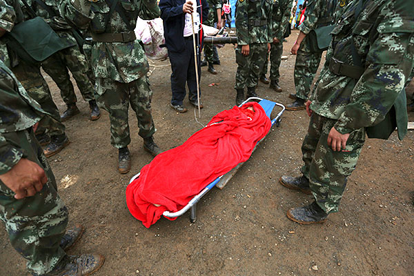 Сотрудники спасательной службы стоят рядом с телом найденного погибшего.