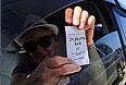 Водитель демонстрирует талон с порядковым номером, в котором указано время заезда и номер автомобиля, переправляющегося через Керченскую переправу, на накопительной площадке у аэропорта "Керчь".