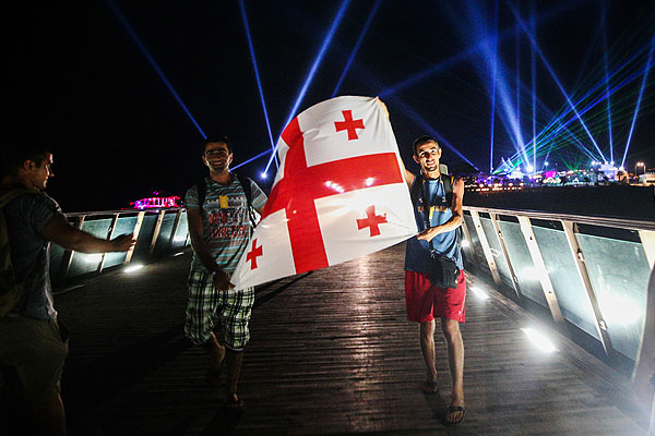 Гости фестиваля проносят флаг Грузии.
