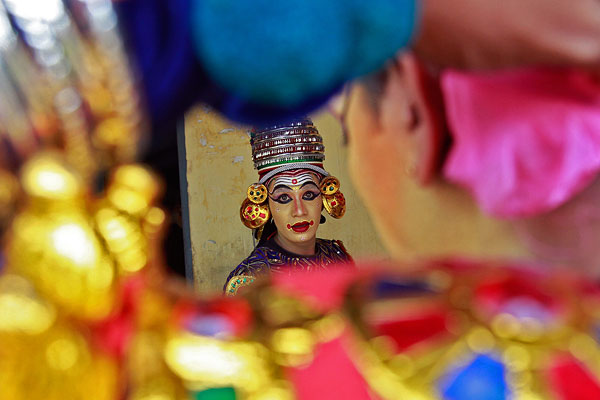 Танцоры готовятся к выступлению на ежегодном празднике урожая "Онам" в Индии.