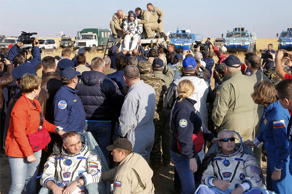 Специалисты поисково-спасательных групп эвакуируют космонавта из спускаемого аппарата.