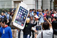 Мужчина в маске Стива Джобса держит картонную копию нового смартфона в первый день продаж iPhone 6 в Токио.