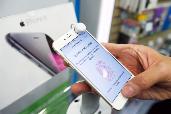 Покупатель проверяет работоспособность функции Touch ID на новом iPhone 6.