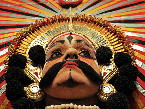 Артист в национальном костюме ждет начала праздника в Бангалоре, Индия.