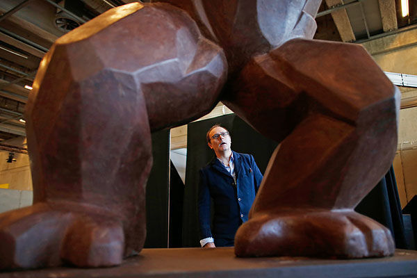 Французский шоколатье Жан-Поль Эвин смотрит на четырехметрового Кинг-Конга, созданного для 20-го Парижского Салона Шоколада.