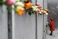 По традиции люди вставляли розы в сочленение плит стены в память о людях, погибших при попытке побега в Западный Берлин из ГДР.