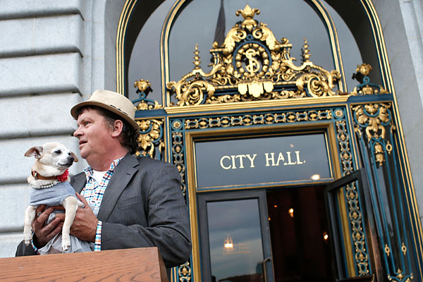 Чихуахуа Фрида со своим хозяином Дином Кларком у мэрии Сан-Франциско, где она в течение одного дня исполняла обязанности главы города. Кларк заплатил пять тысяч долларов, чтобы выкупить необычный лот на аукционе в поддержку бездомных животных.