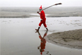 Индийский мужчина в костюме Санта-Клауса после очистки берегов реки Ганг в городе Аллахабад