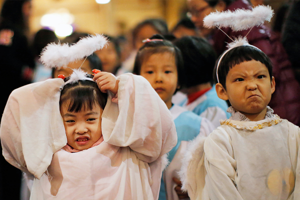 Дети в костюмах ангелов во время рождественской мессы в католической церкви Пекина