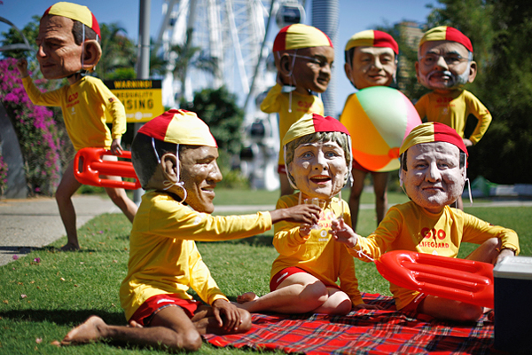 Демонстранты в масках лидеров G20 и в форме австралийских пляжных спасателей в преддверии саммита в Брисбене. ...И почему никто не выбирает для таких шуток формат спасателей Малибу?