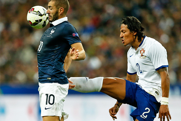 Французский футболист Карим Бензема (слева) бросает вызов португальцу Бруну Алвеш во время товарищеского футбольного матча в Сен-Дени под Парижем. А после матча они будут снова обниматься.