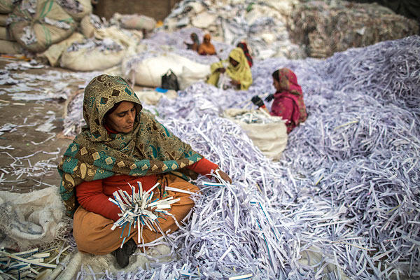 Сортировка бумаги перед заводской переработкой. Пакистан.