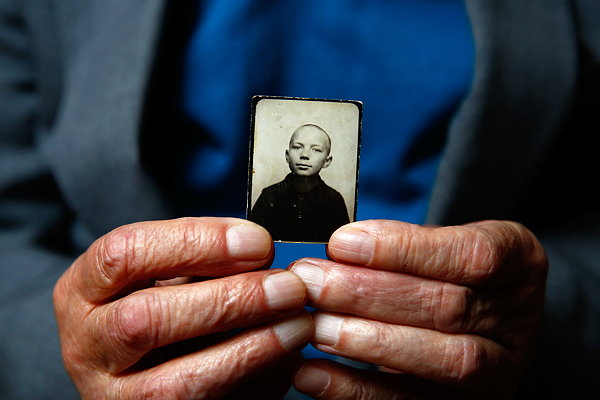 Стефан Сот держит в руках свою фотографию, сделанную до войны. Во время Варшавского восстания в августе 1944 года 13-летний Стефан был отправлен в лагерь в Прушкуве, а затем в Аушвиц-Биркенау. Позже его перевели в трудовой лагерь к югу от Освенцима, где он работал на кухне для офицеров СС.