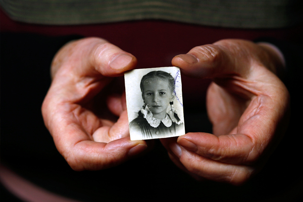 Выжившая узница лагеря смерти Барбара Дониецка держит в руках свою фотографию. Ей было 12 лет во время Варшавского восстания, когда она вместе с матерью была отправлена &#8203;&#8203;в Освенцим.