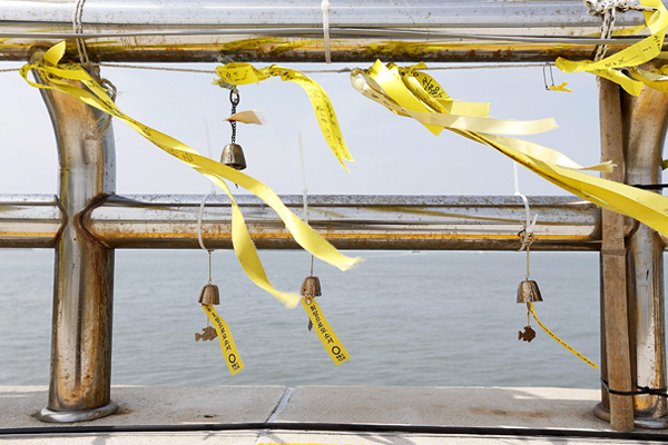 Траурные повязки и желтые ленточки в знак памяти о погибших в бухте Пхэнмок острова Чиндо
