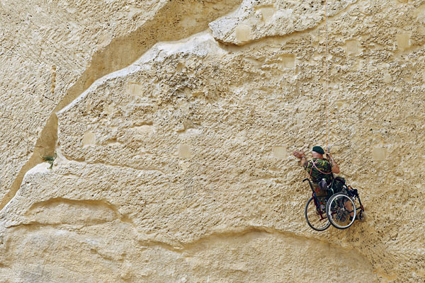 Бывший британский полицейский, потерявший ногу при исполнении служебных обязанностей, спускается с одного из фортов Валетты в рамках благотворительной акции по сбору средств. Мальта.