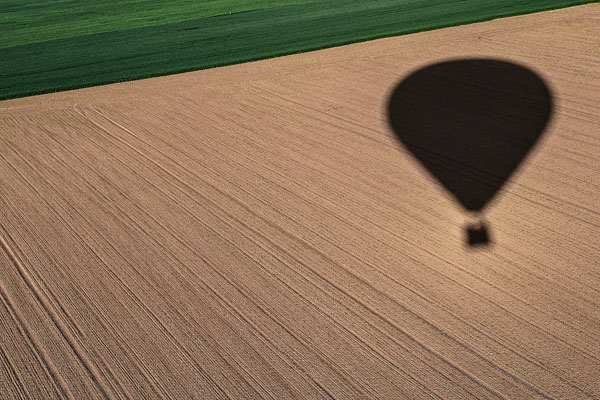 Тень от воздушного шара на поле в заповеднике "Чешский рай" на северо-востоке Чехии