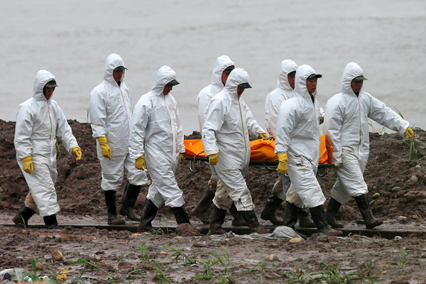 Спасатели переносят тело погибшего