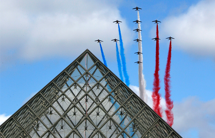 Самолеты "Альфа Джет" пилотажной группы "Патруль де Франс"  выпускают дым с цветами национального флага над Лувром