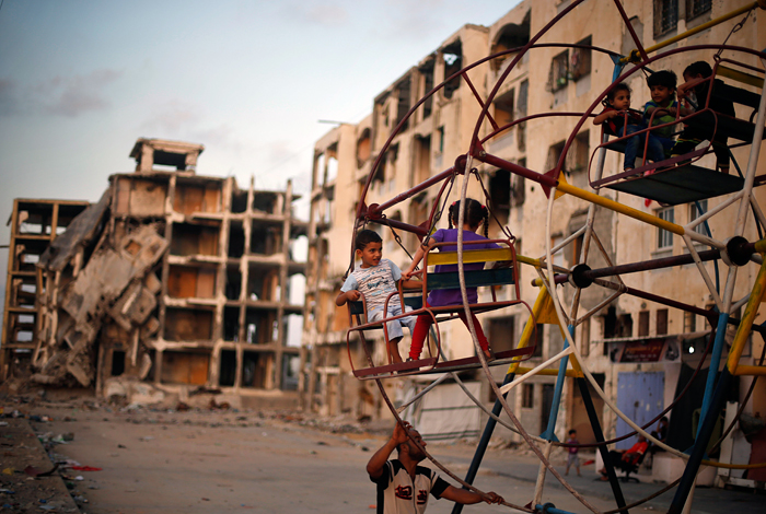 Детский аттракцион во дворе разрушенного дома в секторе Газа