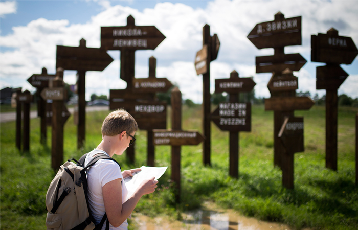 Посетитель рядом с указателями на фестивале в деревне Звизжи