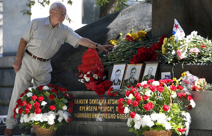 Мужчина возлагает цветы к памятнику в Москве