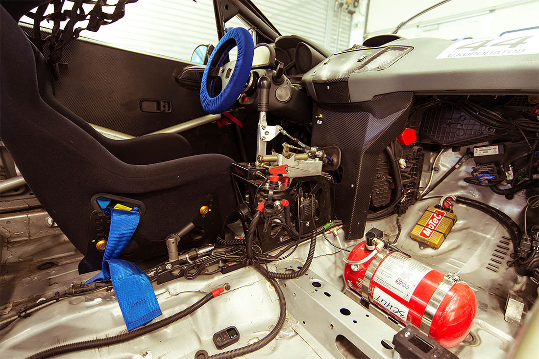 Гоночный автомобиль глубоко модифицирован внутри: ничего, привычного обычному автомобилю тут нет: практически все место в салоне занято каркасом безопасности, предусмотрены специальные системы аварийного пожаротушения, а традиционная внутренняя обшивка и элементы декора отсутствуют как класс. Мужская машина!