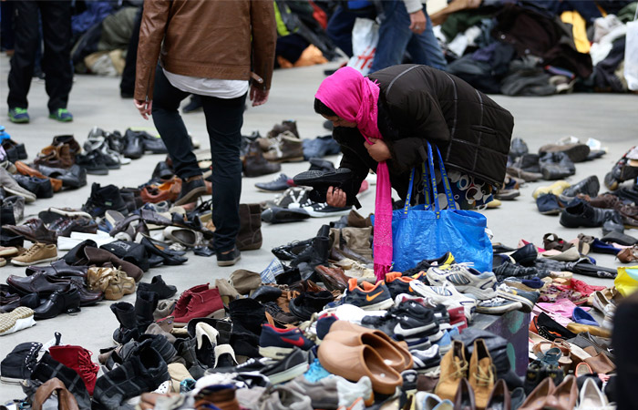 Женщина ищет обувь среди вещей, пожертвованных жителями в германском Дортмунде