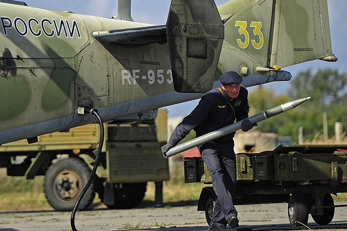 Авиационный специалист заряжает неуправляемую реактивную ракету