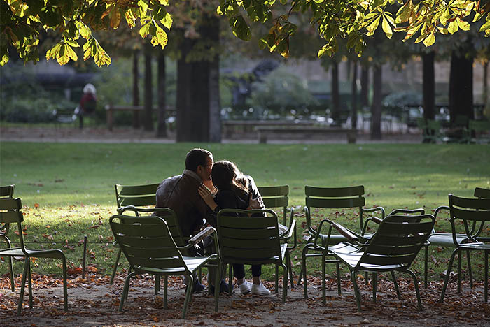 Пара сидит на скамейке в саду Тюильри во Франции