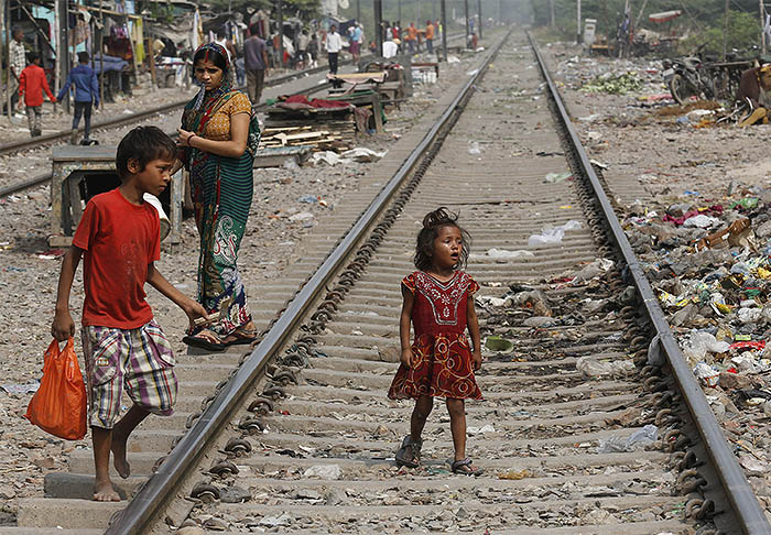 Девочка плачет на рельсах в трущобах Нью-Дели. Несколько дней назад здесь была изнасилована четырехлетняя девочка.