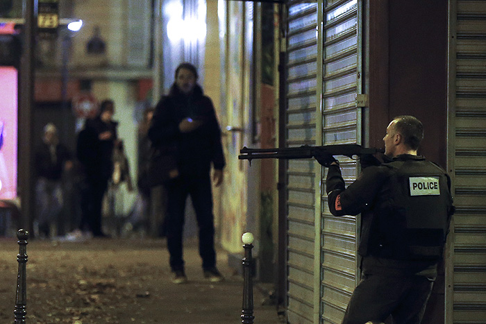 Французский полицейский перед рестораном "Маленькая Камбоджа", где в пятницу вечером произошла стрельба.
