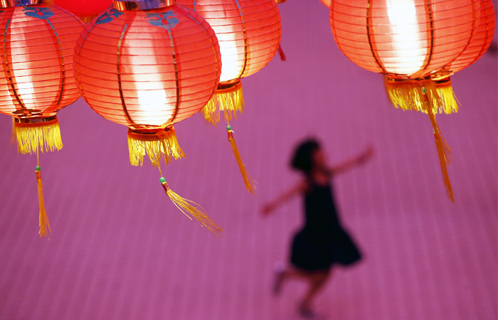 Ребенок играет в храме, украшенном к празднованию китайского Нового года в Куала-Лумпуре, Малайзия